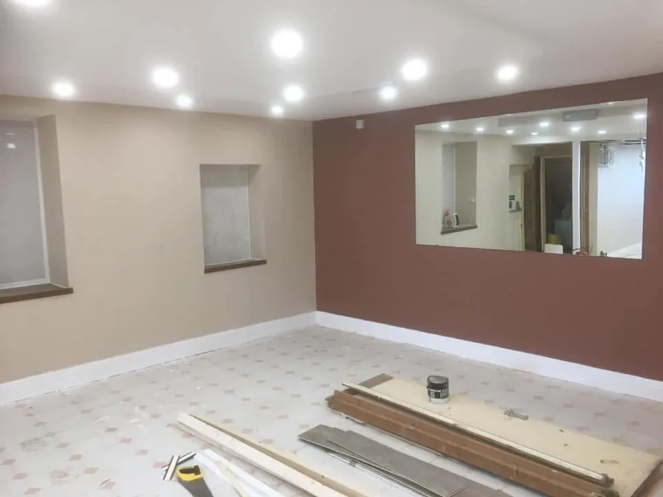 Interior room during renovation showing freshly plastered and painted walls